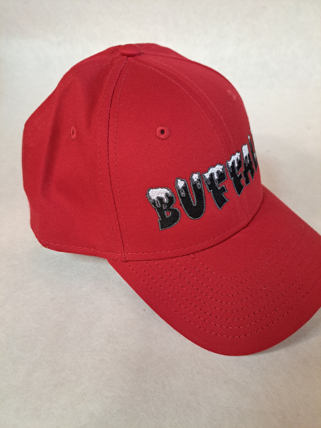 Buffalo with Snow on it with gray border on letters. Red New Era Hat